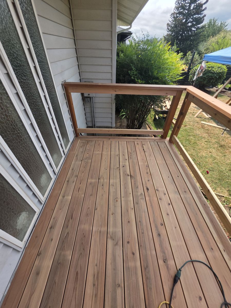 Small cedar deck landing with railing outside a back door in Columbia County Oregon