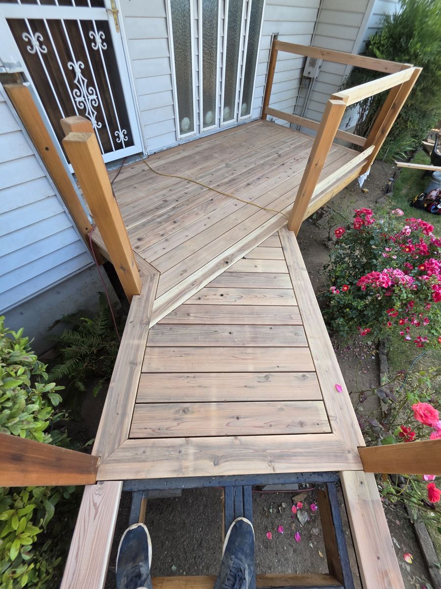 Cedar entry deck and railing beside a rose garden in Columbia County Oregon