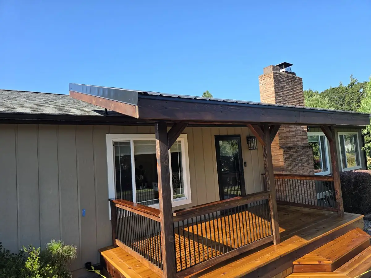 Covered deck with new railing and cedar decking under a timber-framed roof in Columbia County Oregon