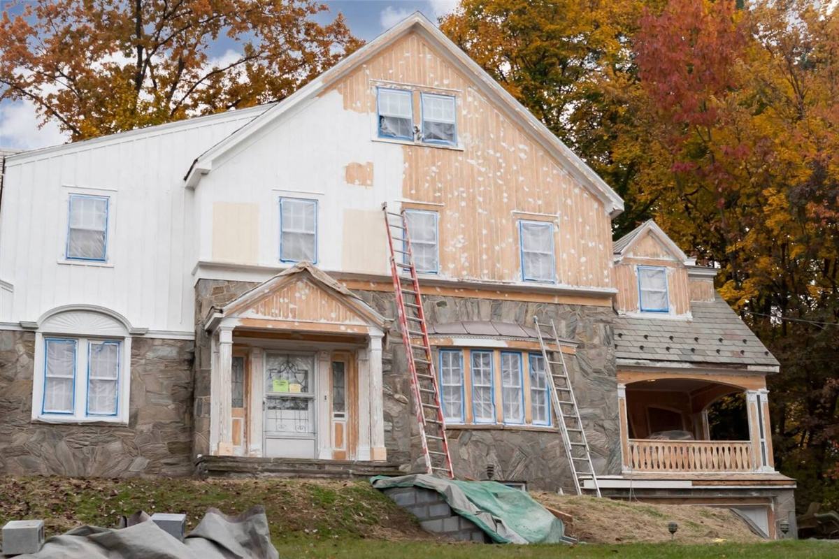 House exterior being prepped and primed for repainting