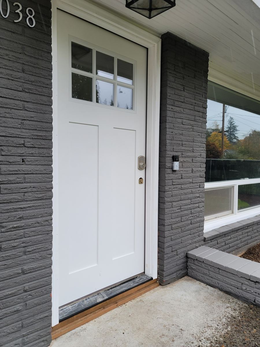 New white craftsman front door with freshly painted brick surround in Columbia County Oregon
