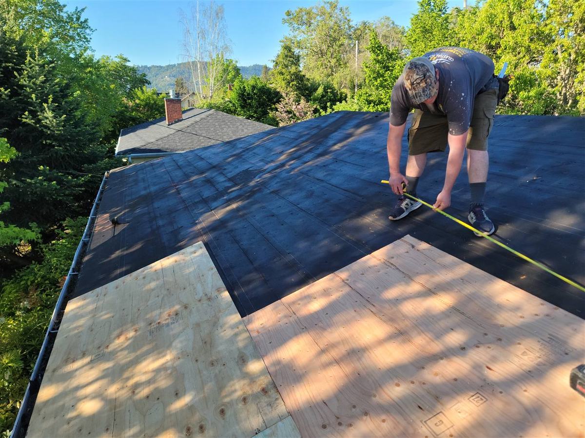 Roofing contractor finishing a shingle roof on an Oregon home