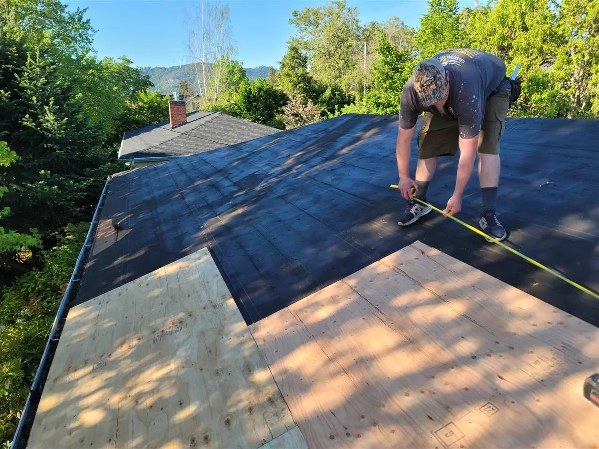 Roofing contractor finishing a shingle roof on an Oregon home