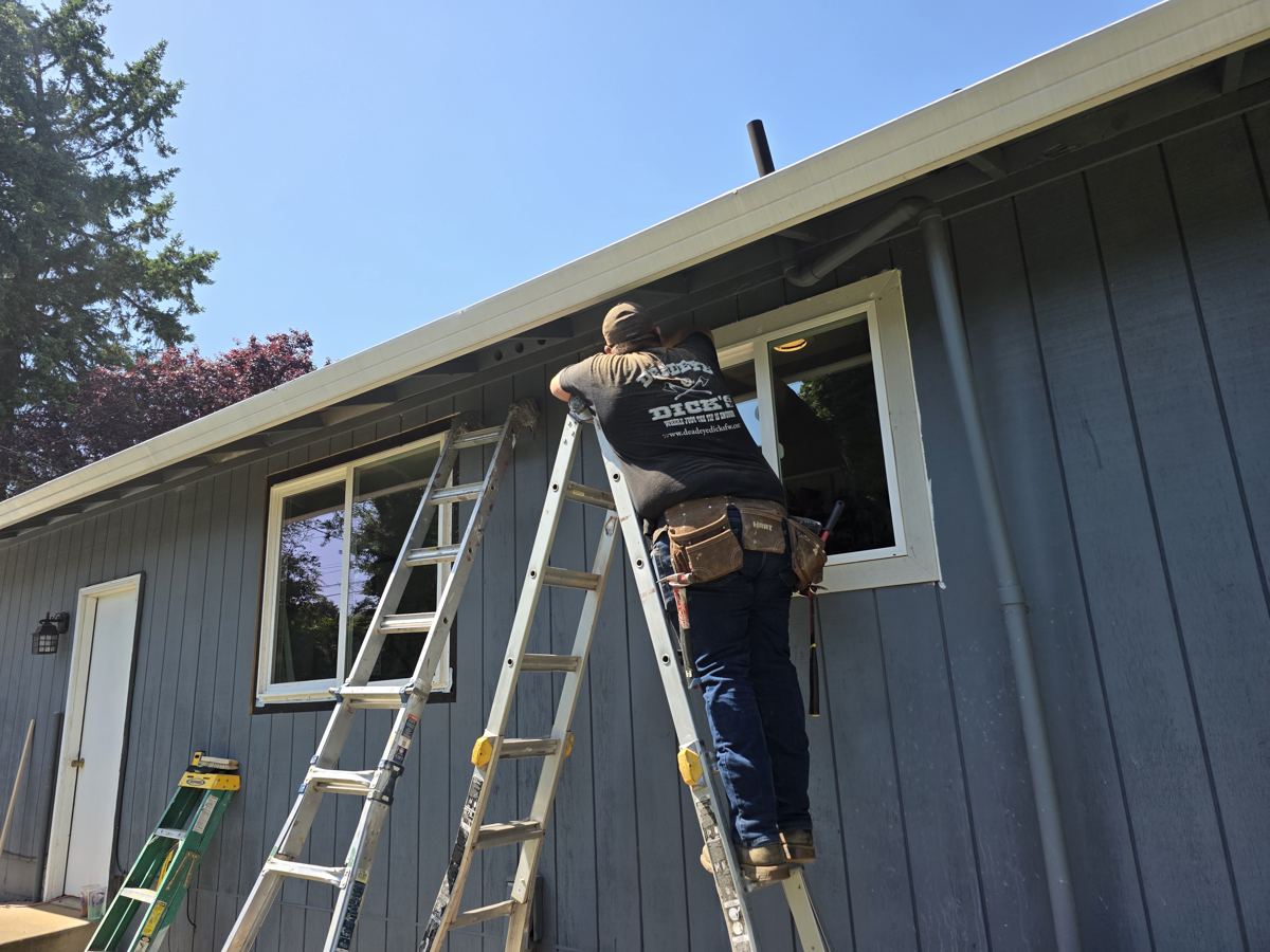 Crew installing a replacement window on a board and batten home in Columbia County Oregon